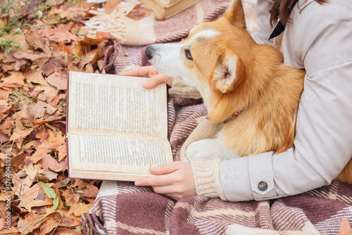 Woman with Corgi dog readin...