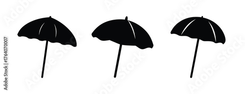 Three black beach umbrellas set side by side on a light background a symbol of summer and relaxation