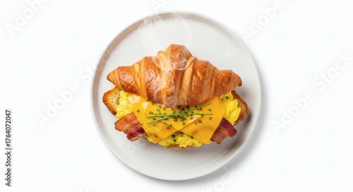 Croissant breakfast sandwich on white plate