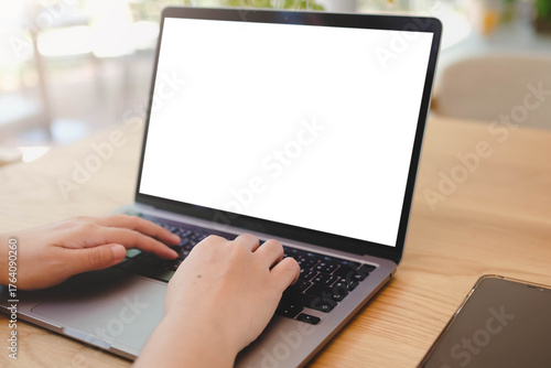 A person's hands typing on a laptop with a blank white screen in a bright, modern office or cafe. A versatile mockup for remote work, business, or education.