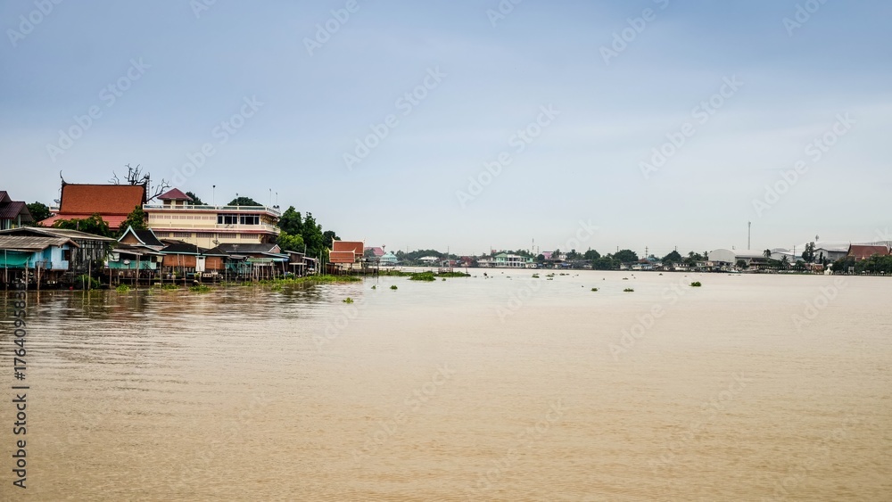 Fototapeta premium Reflection of Nature: A Scenic Journey Along the River Banks of the City After the Flood Under a Vibrant Sky