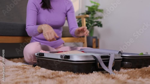 Woman packing clothes in suitcase for travel.