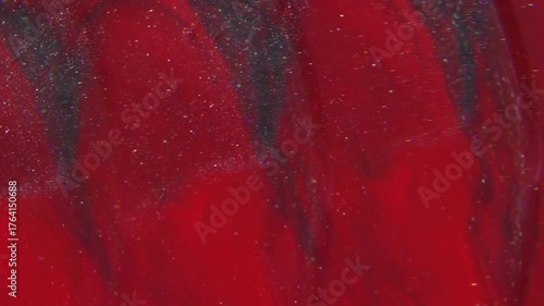 Vivid paint stream. Blur sparkling blend. Color glitter spilling defocused lens. Red dye dissolving in black liquid blur abstract background.