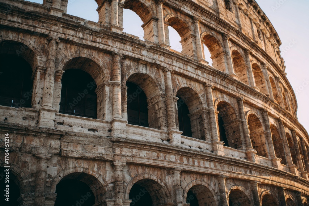 Fototapeta premium Ancient stone arches of a historic amphitheater glow in sunlight.