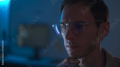 Cybersecurity engineer working late at computer in dark office