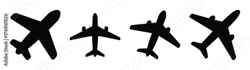 Set of four black airplane silhouettes with slightly textured appearances displaying different orientations and angles