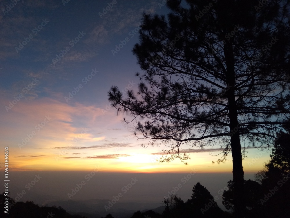 Fototapeta premium The morning sun rises on the summit of Doi Fah Hom Pok in northern Thailand.