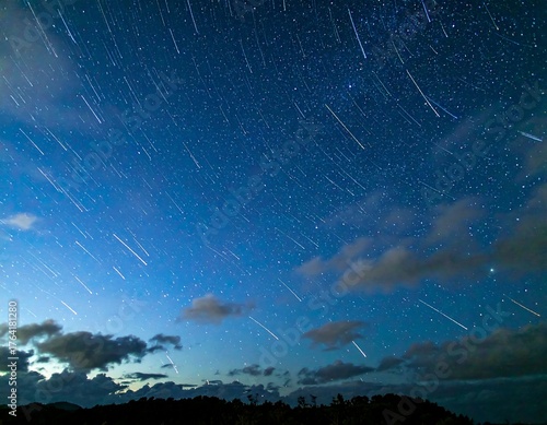 Star trails over dark landscape