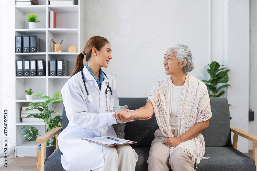 Fototapeta premium Doctor checking arm of elderly woman, providing healthcare consultation. Focus on senior care and medical check ups