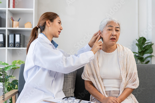 Healthcare professional performing an ear examination on an elderly patient, assessing hearing health and providing consultation