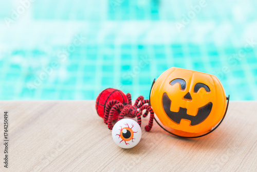 Red spider with eyeball and Halloween pumpkin lantern with space on swimming pool background, outdoor day light, Happy halloween background idea