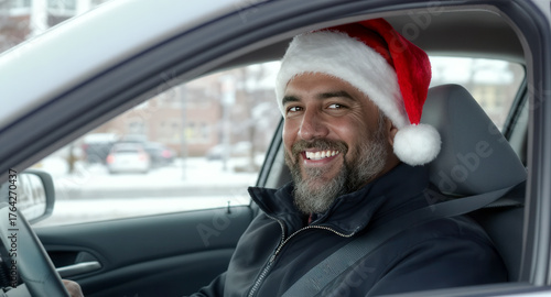Smiling taxi driver in a Santa claus hat driving a car in the city streets. City transport services during Christmas period concept.