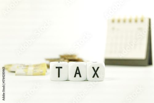 Tax Season: tax time reminder background digitally generated image stock photo copy space white dice spelling TAX horizontally coins stacks foreground against money bank and coins and calendar