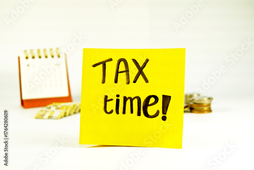Tax Season: tax time reminder background digitally generated image stock photo copy space yellow note pad vertically with coins stacks and calendar background