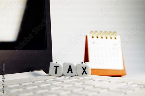 Tax Season: tax time reminder background digitally generated image stock photo copy space white dice horizontally stack on the computer with coins stacks foreground and calendar background 