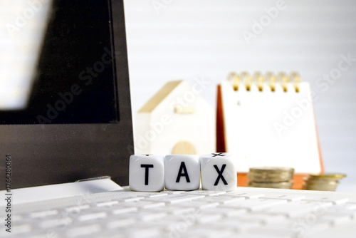 Tax Season: tax time reminder background digitally generated image stock photo copy space white dice vertically stack on the computer with coins stacks foreground and white block house calendar 