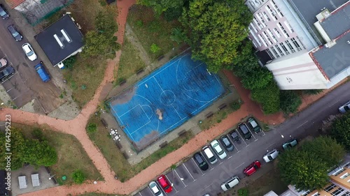 Aerial top down view of sports field between residential building in the city
