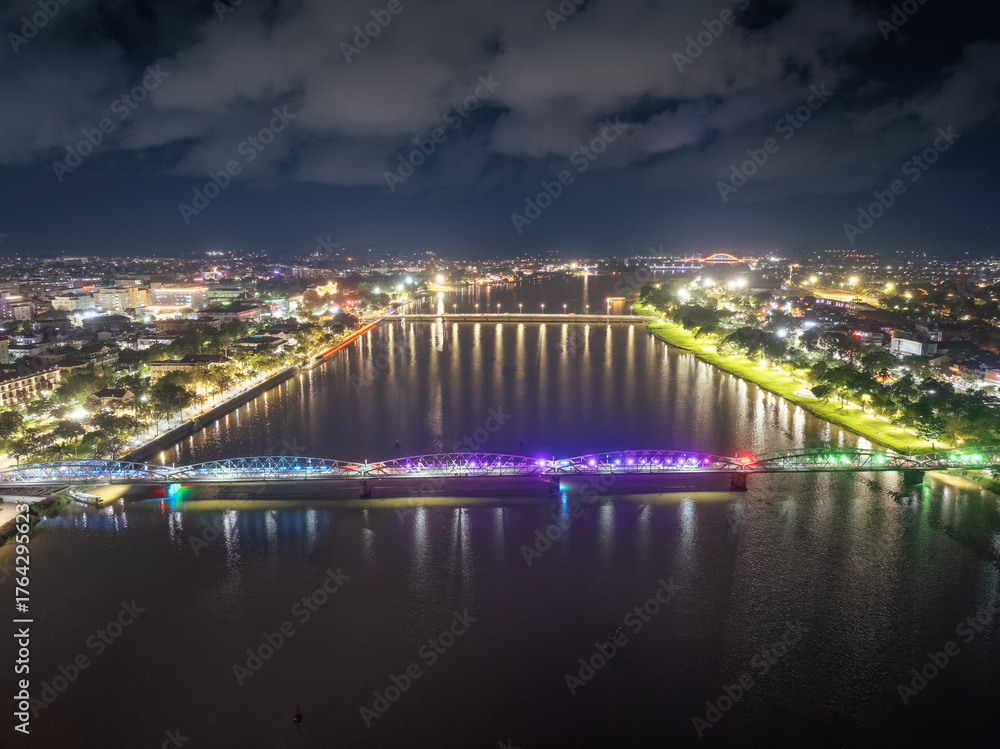 Fototapeta premium Panoramic view of Truong Tien Bridge in Hue City at night. Bridge illuminated all over with blurry reflection on. Travel and landscape concept