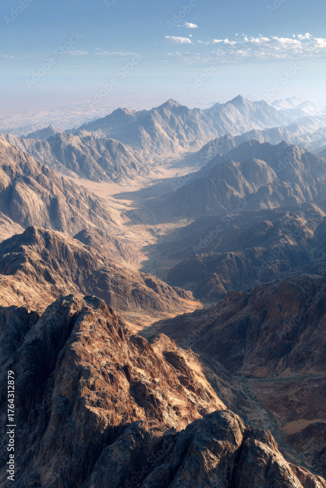 Obraz premium Majestic mountain landscape showcasing rugged peaks and valleys under a clear blue sky, highlighting the beauty of nature and the vastness of the wilderness