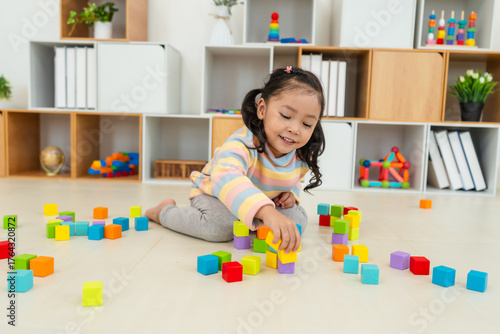 toddler girl playing block toy to stacks building cubes at home