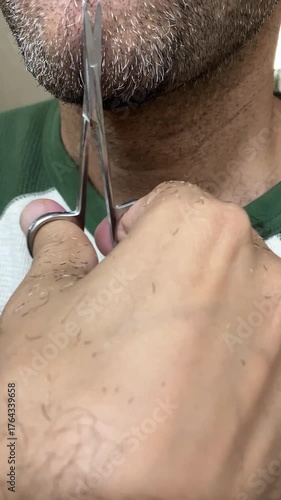 Trimming the beard with a scissor. 