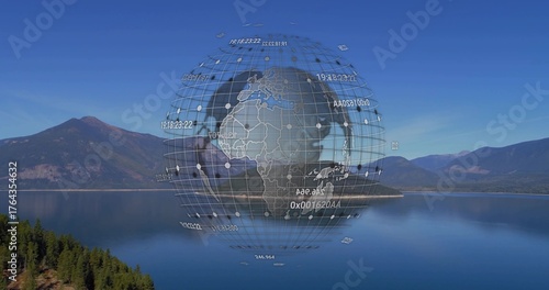 Hovering digital globe wireframe floating above lake in mountain valley, with numeric data labels