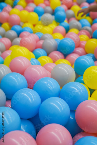 A pile of colorful plastic balls in various hues like blue, pink, yellow, and gray