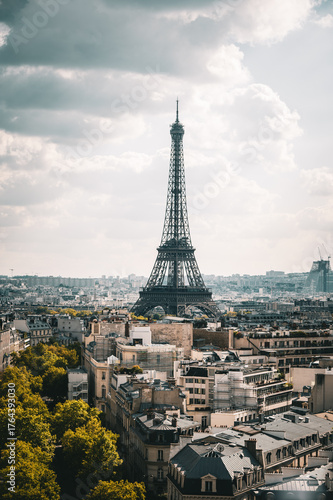 Fotografi Iconic Eiffel Tower dominating Paris Skyline on a Cloudy Day