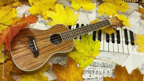 wooden ukulele rests on the keys of an old upright piano, surrounded by golden maple leaves and handwritten sheet music, creating a warm and nostalgic atmosphere for musical creativity