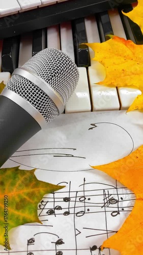 Creating the Sound of Autumn: A Music Producer's Setup with MIDI Keyboard, Microphone, and Headphones Surrounded by Warm Fall Leaves and Handwritten Sheet Music embodying seasonal creative inspiration