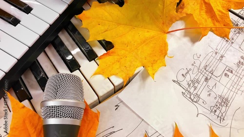 Creating the Sound of Autumn: A Music Producer's Setup with MIDI Keyboard, Microphone, and Headphones Surrounded by Warm Fall Leaves and Handwritten Sheet Music embodying seasonal creative inspiration