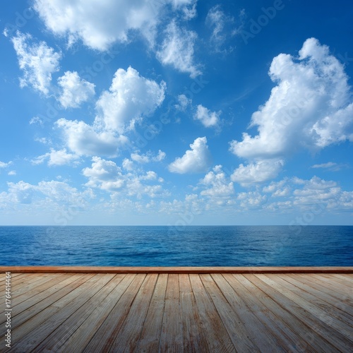 Stunning coastal view from a wooden deck under a bright blue sky with fluffy white clouds