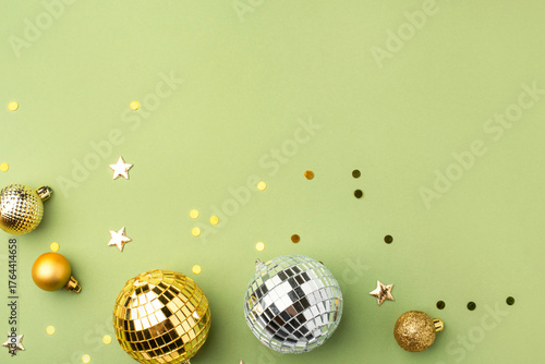 Festive Christmas gold ornaments on a green background.