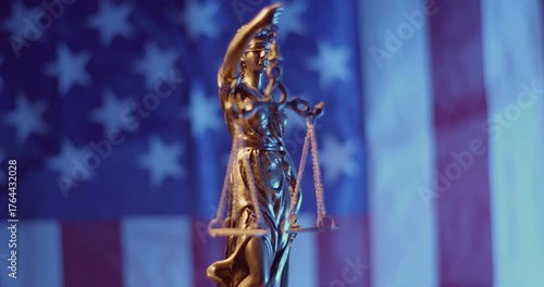 Lady Justice Bronze Statue with an inverted American flag on the background.