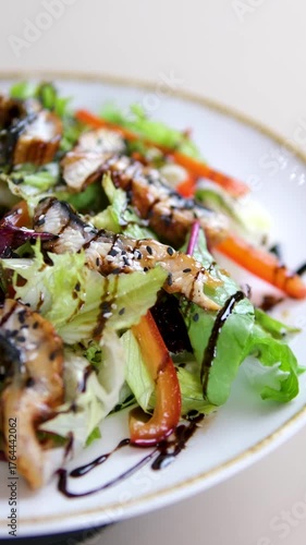 Salad with eel on a white plate, green leaves drizzled with balsamic sauce. High quality 4k footage