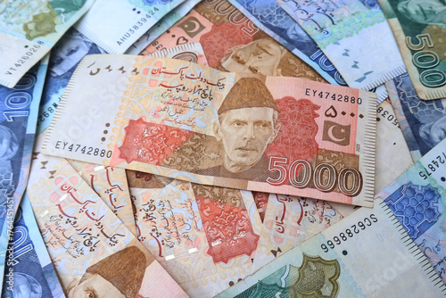 Pakistani paper money of different values placed together, symbolizing finance, economy, savings, and investment in Pakistan. featuring Quaid-e-Azam Muhammad Ali Jinnah portrait and security features.
