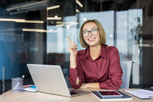 Cuadro en lienzo Happy businesswoman wearing glasses working on laptop in modern office, having a