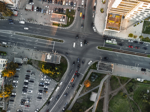 Aerial look-down view of traffic accident at city streets intersection with damaged vehicles in center of crossroad in traffic