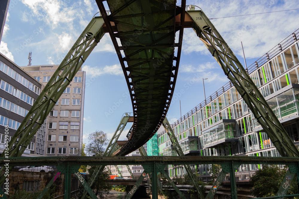 Obraz premium Monorail track curving above city street with modern buildings horizontal