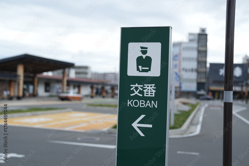 Naklejka premium A green sign with a man on it and the word Koban written in Chinese. The sign is pointing to the right