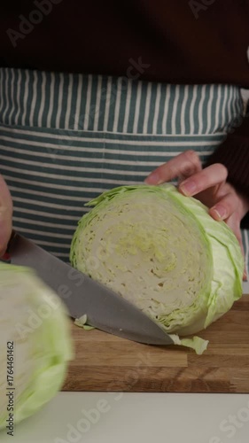 ands cut cabbage in two parts on cutting board