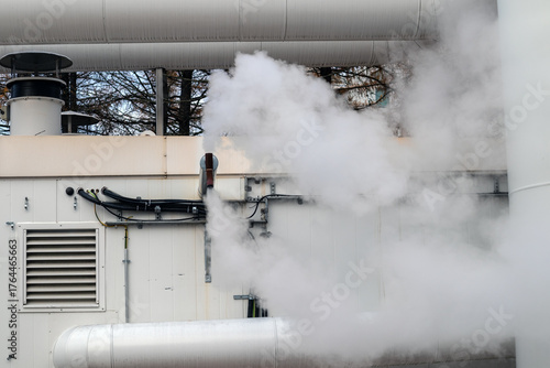 Industrial steam vents release white vapor outdoors
