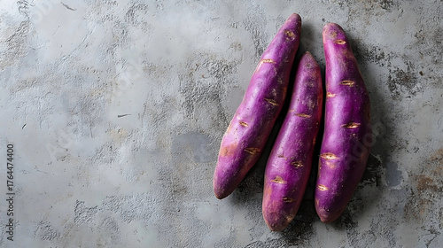 Fresh ube purple sweet potatoes on rustic gray background 