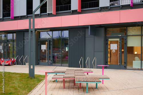 modern nail beauty salon and pizzeria entrance with vibrant outdoor seating and playful decor inviting customers. bright contemporary storefront offers stylish amenities in urban setting