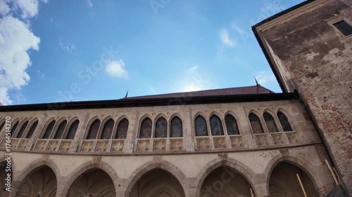 Corvin Castle in Hunedoara: imposing Gothic-Renaissance fortress with stone steps, arches and layered courtyards under a vivid blue sky, showcasing medieval Romanian heritage of Transylvania