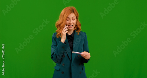 Tableau sur toile Female takes pregnancy test and makes call on smartphone entusiastic