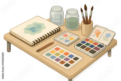 Watercolor painting supplies on wooden table: sketchbook, paint set, brushes, jars of water