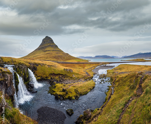 Famous picturesque Kirkjufell mountain and Kirkjufellsfoss waterfall next to Grundarfjörður at West Iceland autumn view.