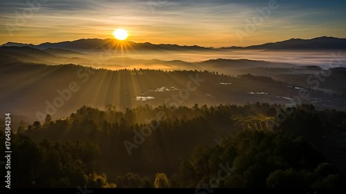 Golden Sunrise Over Mountainous Landscape with Sunbeams and Forest
