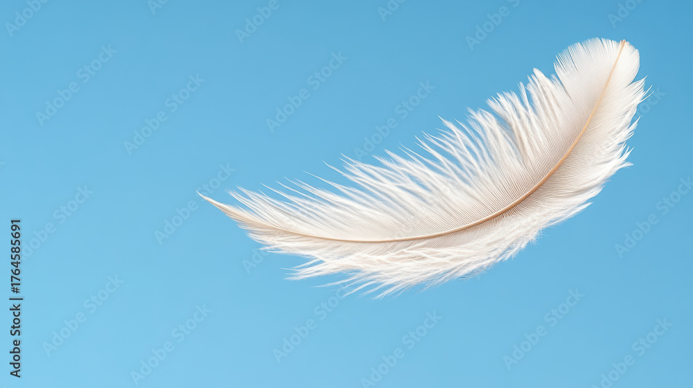 Fototapeta premium White feather floating in blue sky symbolizes purity and lightness, evoking serenity